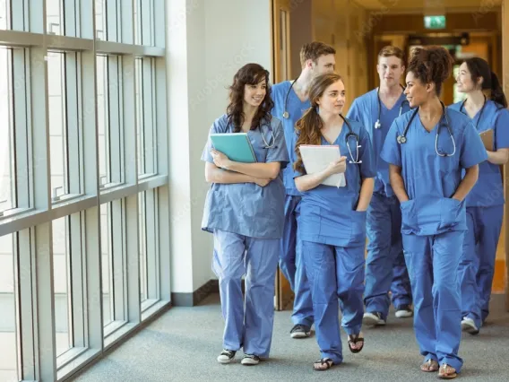 group of women medical professionals walking in hallway talking