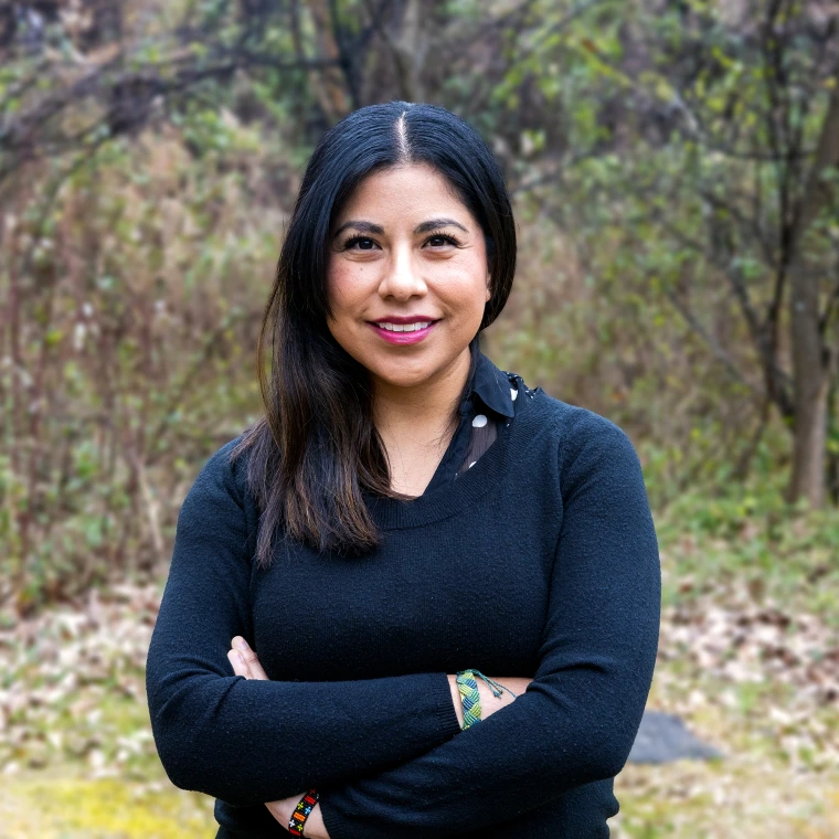 woman standing with arms crossed smiling and facing camera